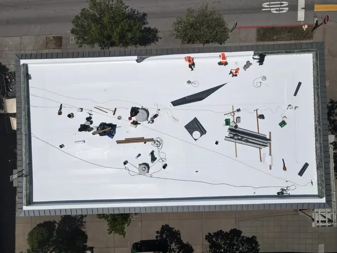 Aerial view of Apollo Roofing replacing flat roof with weather-resistant materials in Sacramento