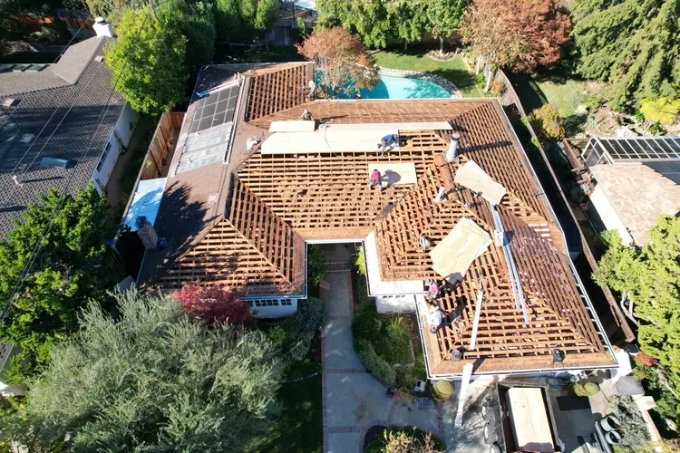 Aerial view of roof replacement in Walnut Creek with crews working on exposed rafters