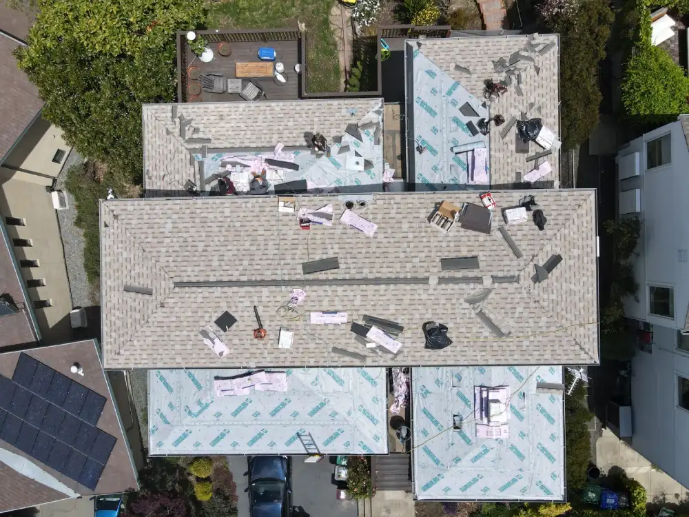 Roofing contractors installing shingles and underlayment on a San Francisco home
