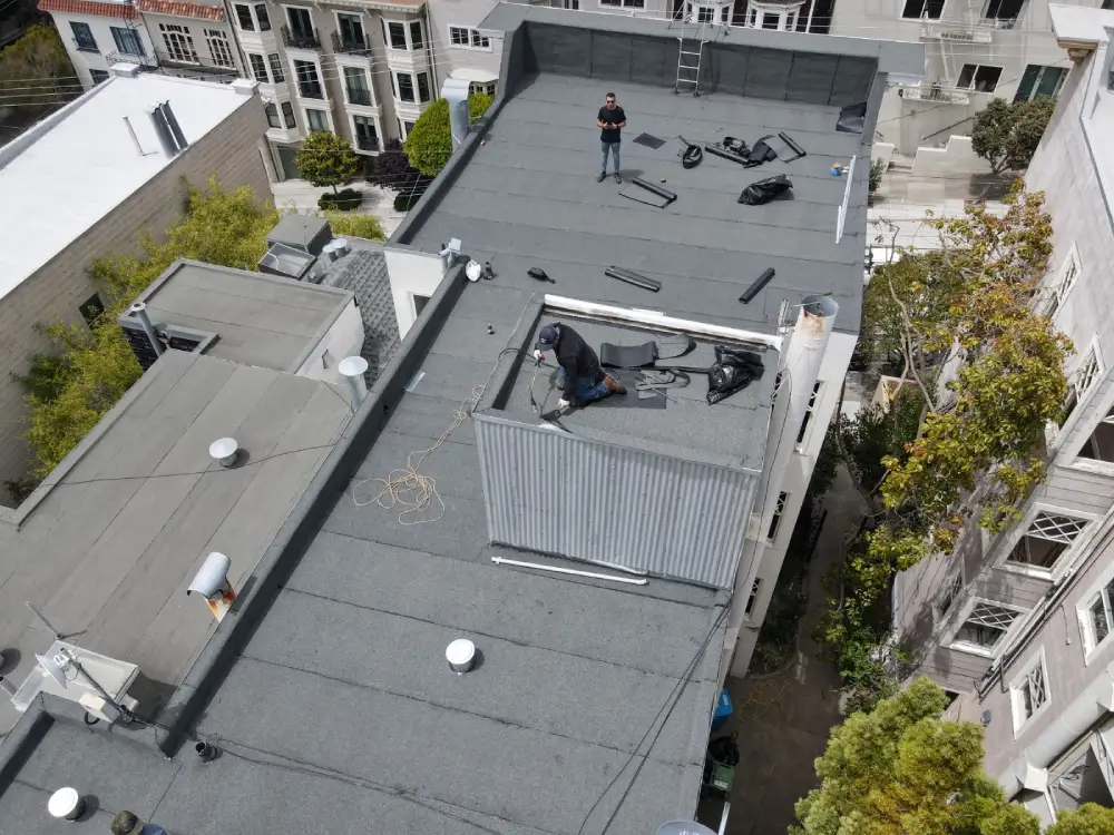 Roofing contractors applying torch down material on flat Sacramento rooftop