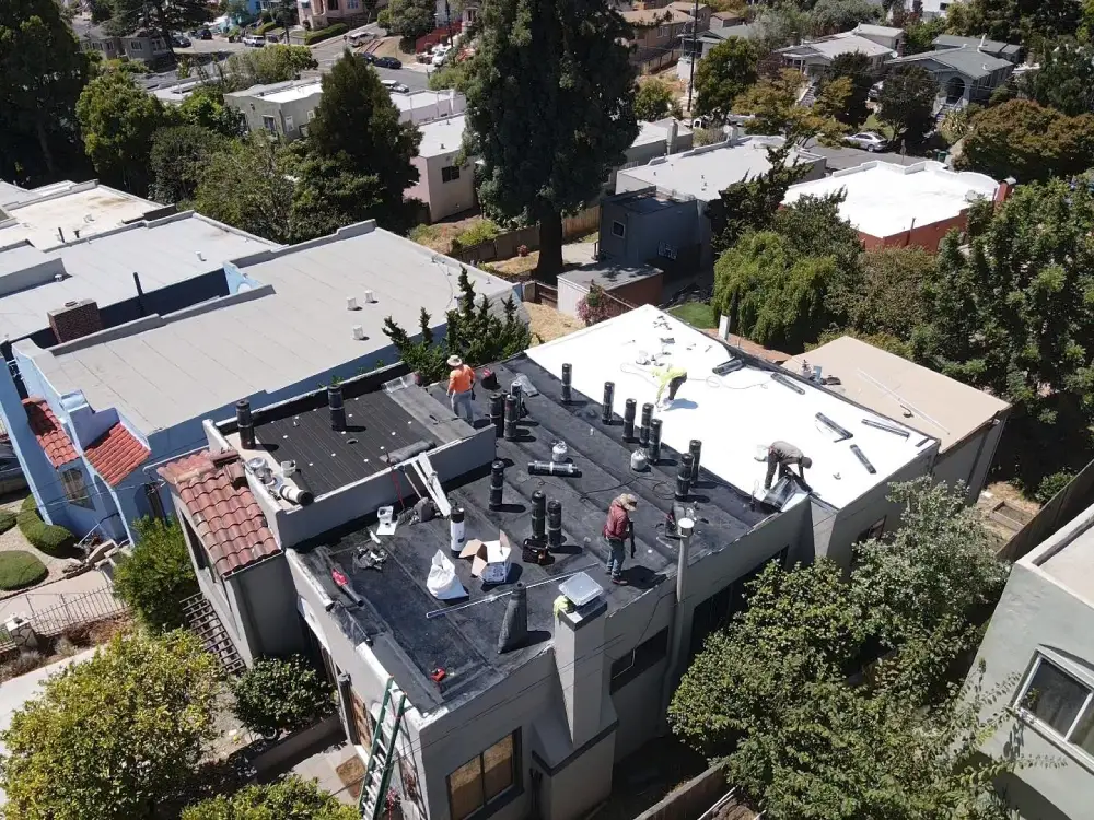 Roofer inspecting torch down flat roof for damage to extend its lifespan in 2026