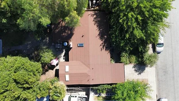 red roof house trees white car